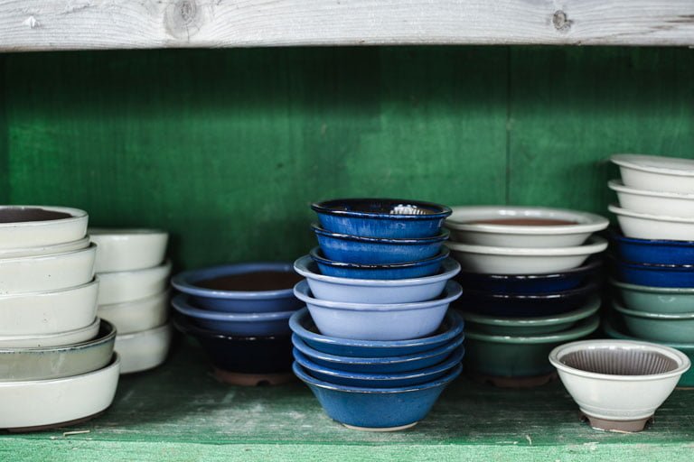 Enamel cookware in a cupboard demonstrating the different colour options and designs.